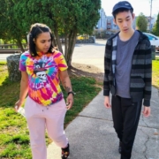 Young man and woman taking a walk on a tree lined sidewalk