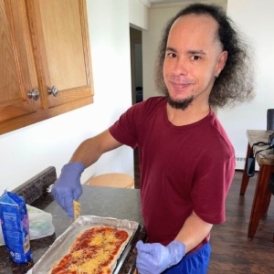 man in kitchen cooking a pasta dish