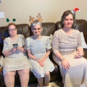 three women sitting on couch wearing holiday items